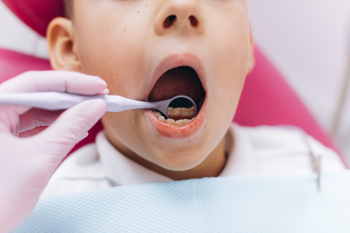 Woman dentist makes a dental examination of the boy mouth