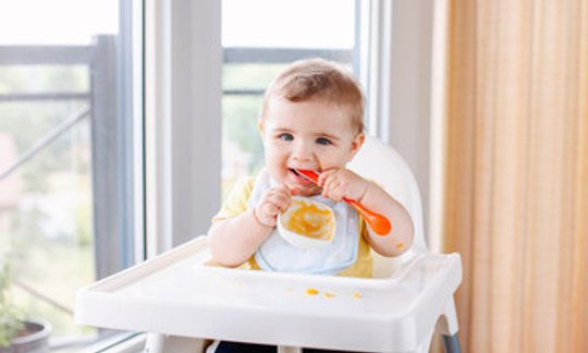 Toddler eating from a baby food pouch