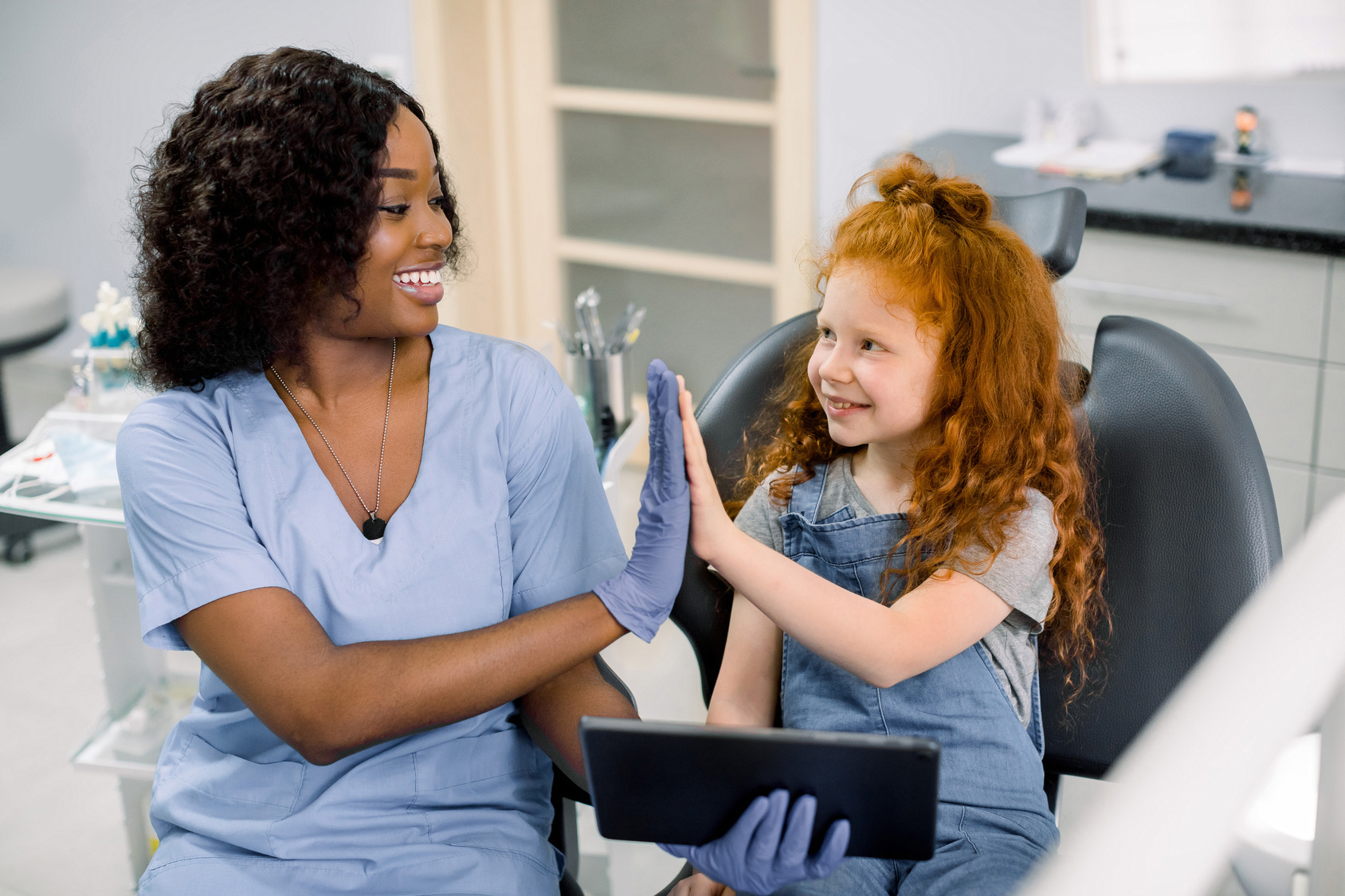 Parent and child reviewing dental insurance coverage at a pediatric dental visit