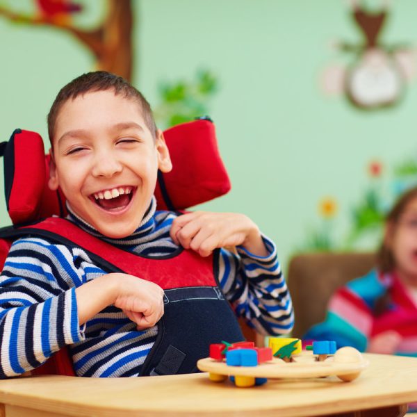 cheerful boy with disability at rehabilitation center for kids with special needs